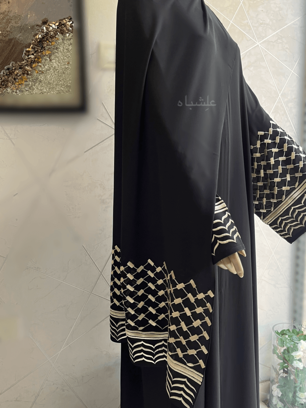 Abaya crafted from premium Nida fabric featuring intricate Keffiyeh embroidery on the sleeves and a soft chiffon Sheila. The Alishbah Keffiyeh Design Abaya blends contemporary elegance with cultural heritage, offering a sophisticated and graceful look.