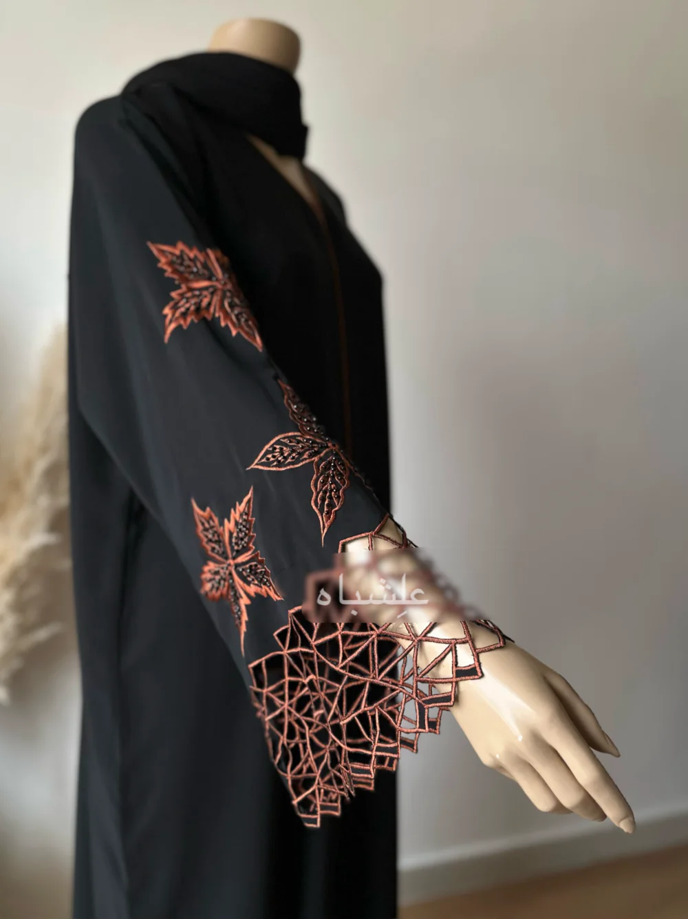 Abaya made from luxurious Nida fabric featuring intricate cutwork embroidery on the sleeves and handwork embellishments on the front panel. The Alishbah Nida Premium Abaya combines elegance and sophistication, offering timeless grace for any occasion.