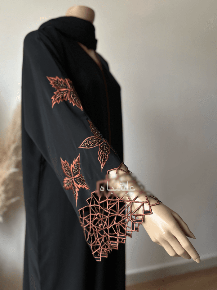 Abaya made from luxurious Nida fabric featuring intricate cutwork embroidery on the sleeves and handwork embellishments on the front panel. The Alishbah Nida Premium Abaya combines elegance and sophistication, offering timeless grace for any occasion.