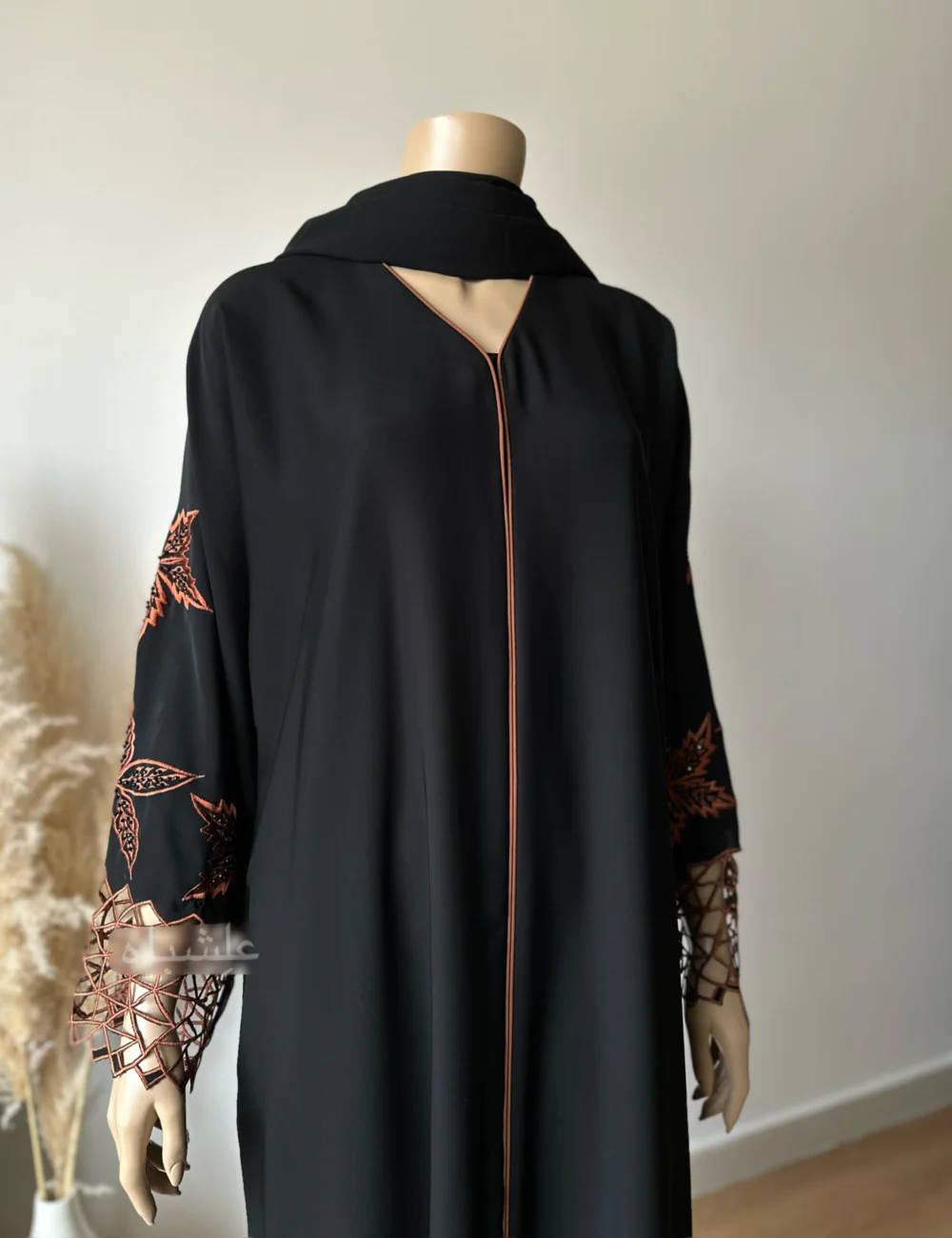 Abaya made from luxurious Nida fabric featuring intricate cutwork embroidery on the sleeves and handwork embellishments on the front panel. The Alishbah Nida Premium Abaya combines elegance and sophistication, offering timeless grace for any occasion.