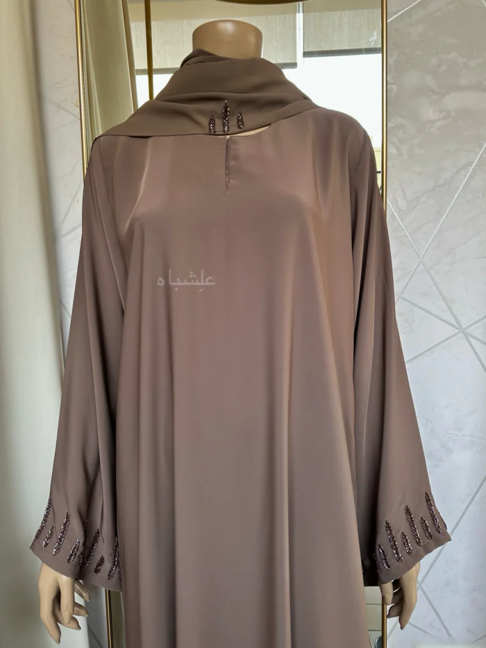 Abaya featuring delicate handwork embellishments on the sleeves and slits, crafted from high-quality materials. The Alishbah Pink Abaya blends timeless elegance with modern sophistication, suitable for both formal and casual occasions."