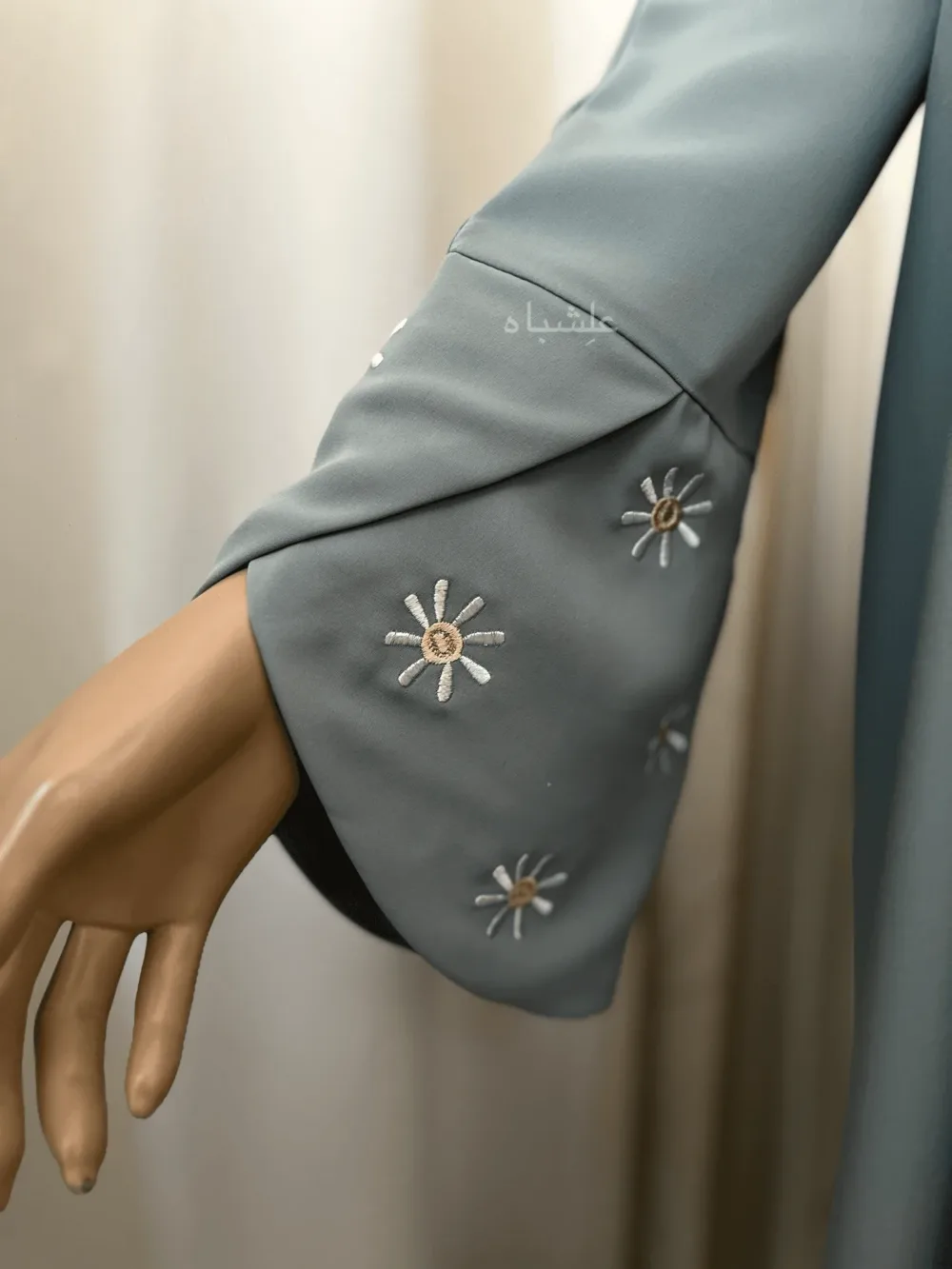 Abaya in green sage featuring premium Nida fabric with delicate floral embroidery on the overlapped sleeves and sheila. The Green Sage Nida Premium Abaya by Alishbah offers a blend of luxury, sophistication, and timeless elegance