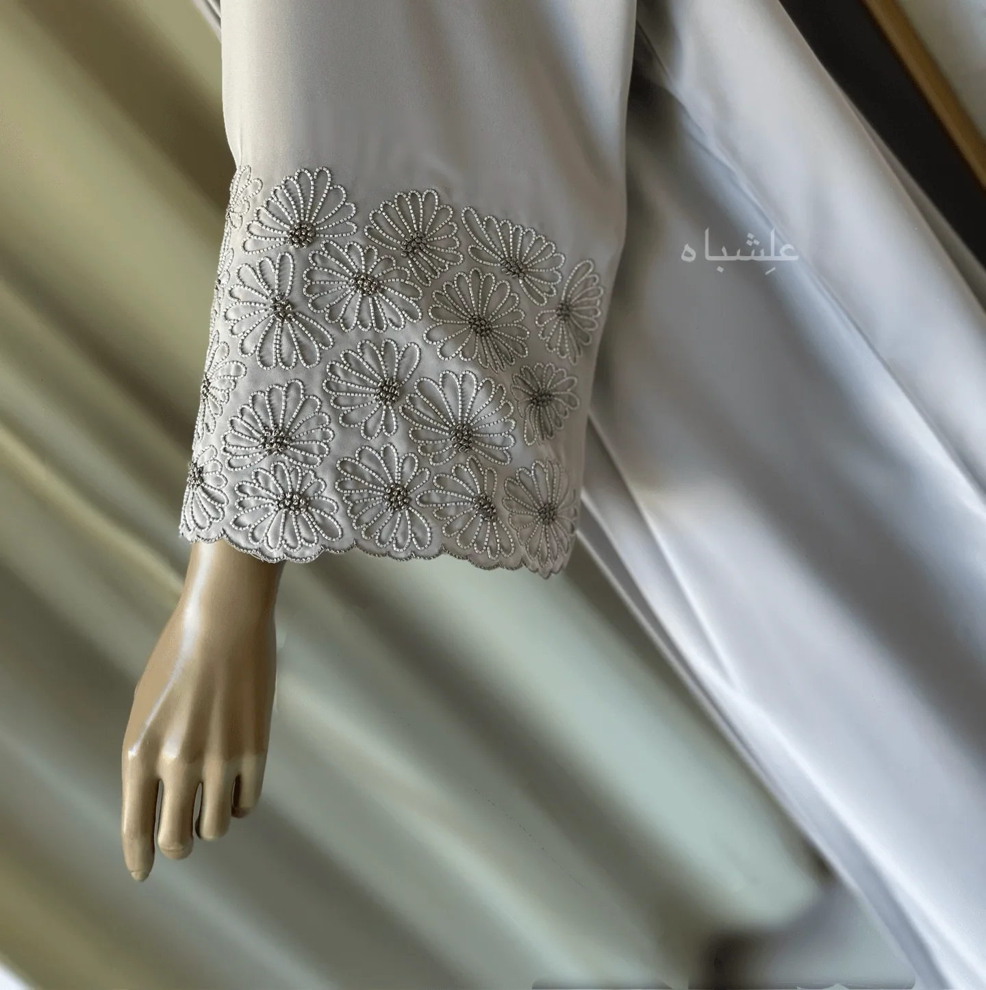 Eternal Petals of Grace Nida Premium Abaya with Floral Handwork 6 Alishbah Eternal Petals of Grace Nida Premium Abaya with floral handwork. The abaya is crafted from luxurious Nida Premium fabric, featuring delicate floral handwork including tiny scallops and French knots that form elegant patterns along the cuffs and neckline. The ensemble is completed with a soft chiffon sheila (headscarf) that drapes gracefully, enhancing the sophisticated and timeless design. This abaya blends traditional handwork with contemporary elegance, showcasing high-quality craftsmanship and refined style.