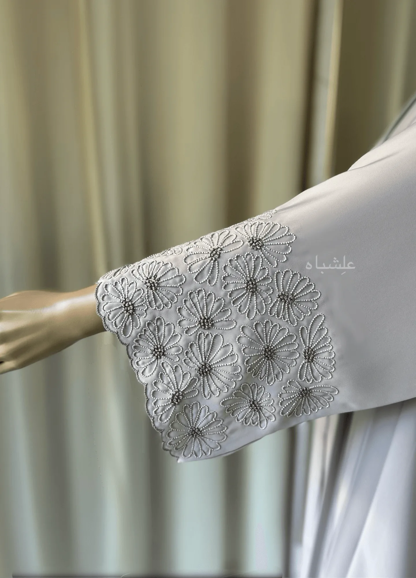 Eternal Petals of Grace Nida Premium Abaya with Floral Handwork 7 Alishbah Eternal Petals of Grace Nida Premium Abaya with floral handwork. The abaya is crafted from luxurious Nida Premium fabric, featuring delicate floral handwork including tiny scallops and French knots that form elegant patterns along the cuffs and neckline. The ensemble is completed with a soft chiffon sheila (headscarf) that drapes gracefully, enhancing the sophisticated and timeless design. This abaya blends traditional handwork with contemporary elegance, showcasing high-quality craftsmanship and refined style.