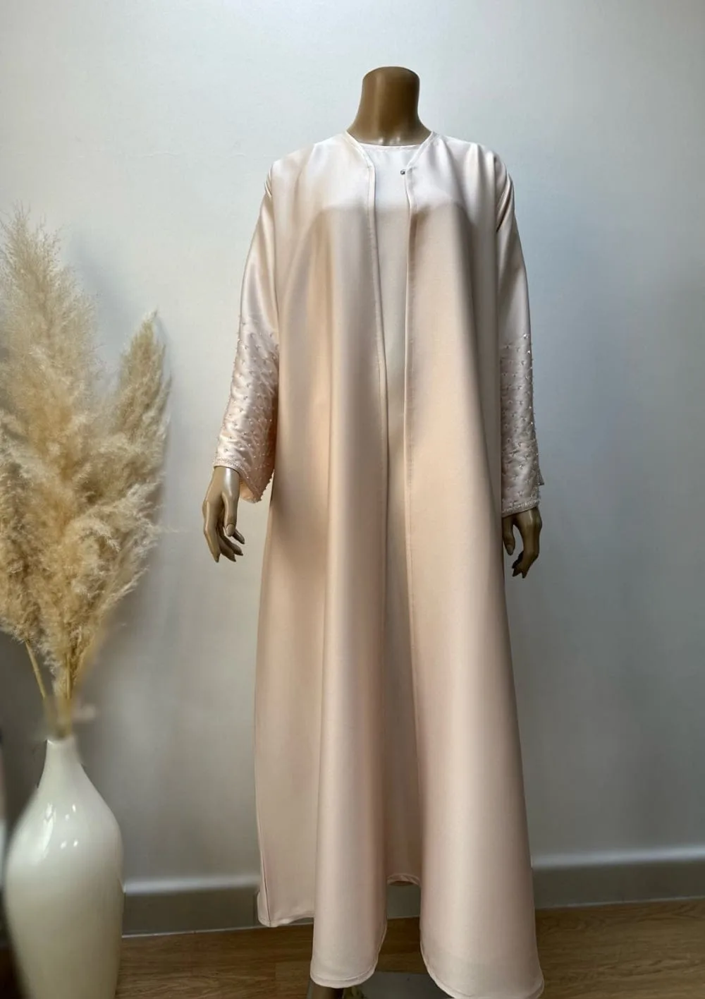 Layla Al-Hadeer Abaya by Alishbah 3 Front full view of the Candy Crape Abaya set by Alishbah, displaying the outer abaya and inner abaya. The outer abaya features a classic, flowing design in a rich color with delicate stone embellishments on the sleeves, while the inner abaya is visible underneath. The luxurious Korean crape fabric drapes elegantly, highlighting the sophisticated blend of traditional and modern styles. The absence of the sheila (headscarf) emphasizes the intricate details and graceful silhouette of the abaya.