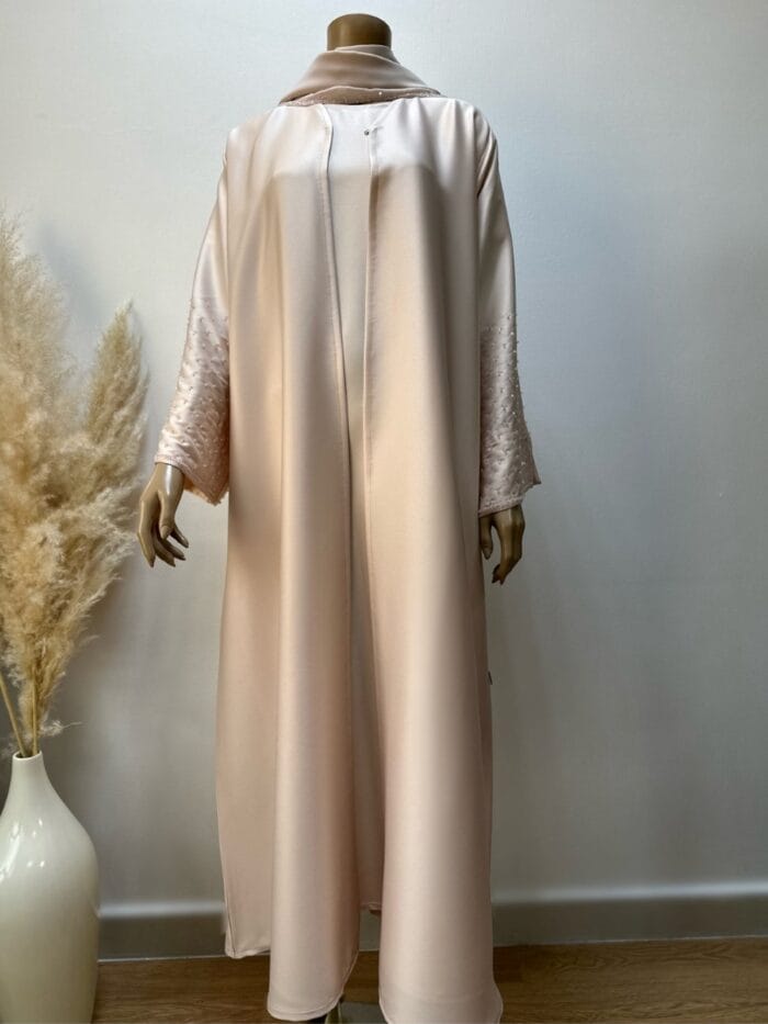 Front view of the Candy Crape Abaya set by Alishbah, showcasing the full ensemble. The image features the outer abaya, a classic, long, and flowing garment in a rich, elegant color with intricate stone embellishments on the sleeves. Underneath, the inner abaya is visible, adding layers to the modest outfit. The sheila (headscarf) completes the set, draped gracefully, matching the outer abaya’s design. The luxurious Korean crape fabric shines with subtle sophistication, reflecting a perfect blend of traditional and contemporary styles.