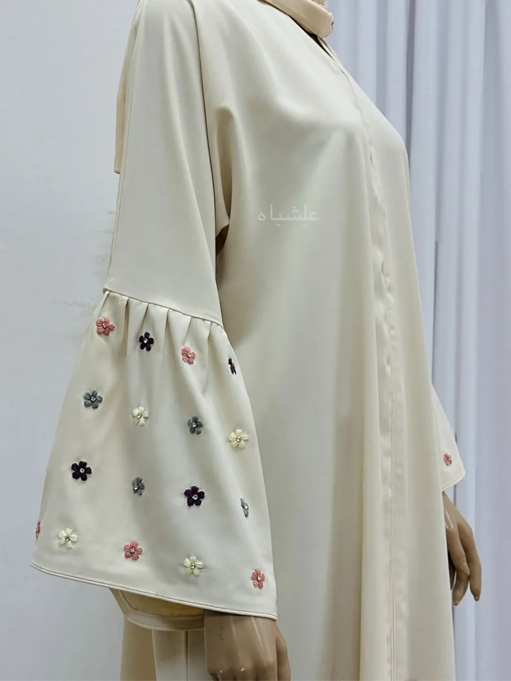 Close-up of Floral Bliss Cream Abaya from Alishbah, featuring delicate floral embroidery on Noor fabric