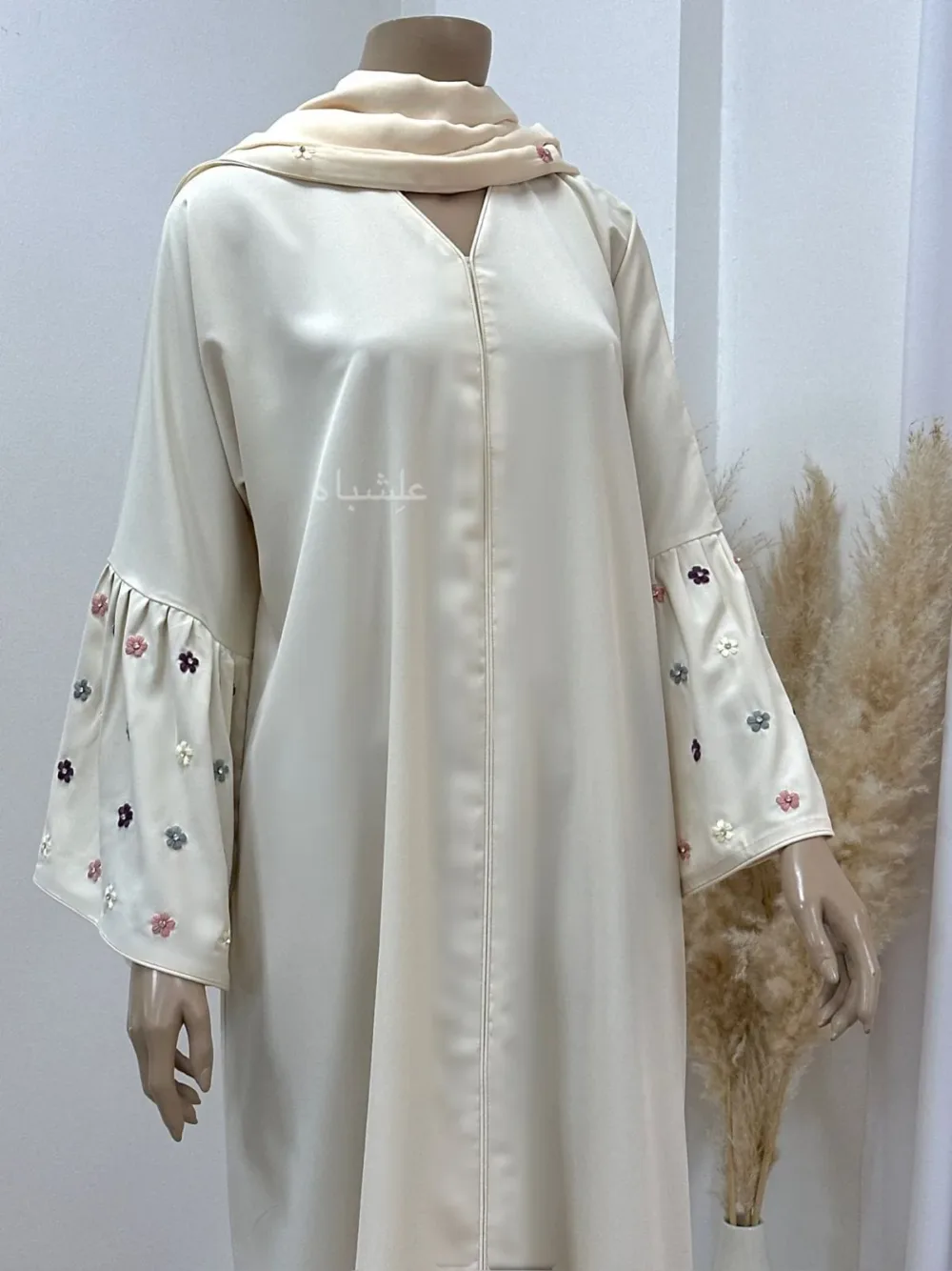 Close-up of Floral Bliss Cream Abaya from Alishbah, featuring delicate floral embroidery on Noor fabric