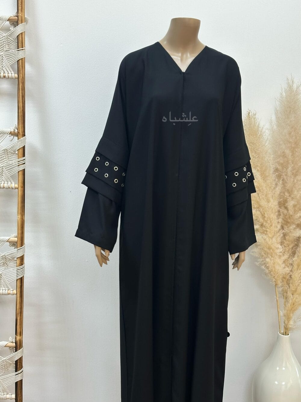 A stylish Korean crape abaya featuring handcrafted button hole embellishments, paired with a soft chiffon Sheila for versatile styling