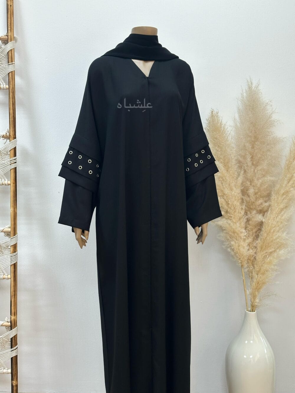 A stylish Korean crape abaya featuring handcrafted button hole embellishments, paired with a soft chiffon Sheila for versatile styling