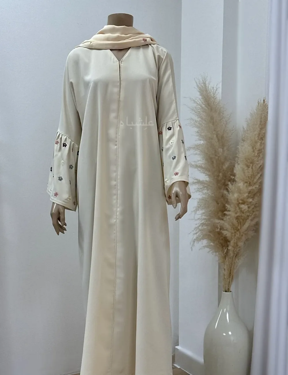 Close-up of Floral Bliss Cream Abaya from Alishbah, featuring delicate floral embroidery on Noor fabric