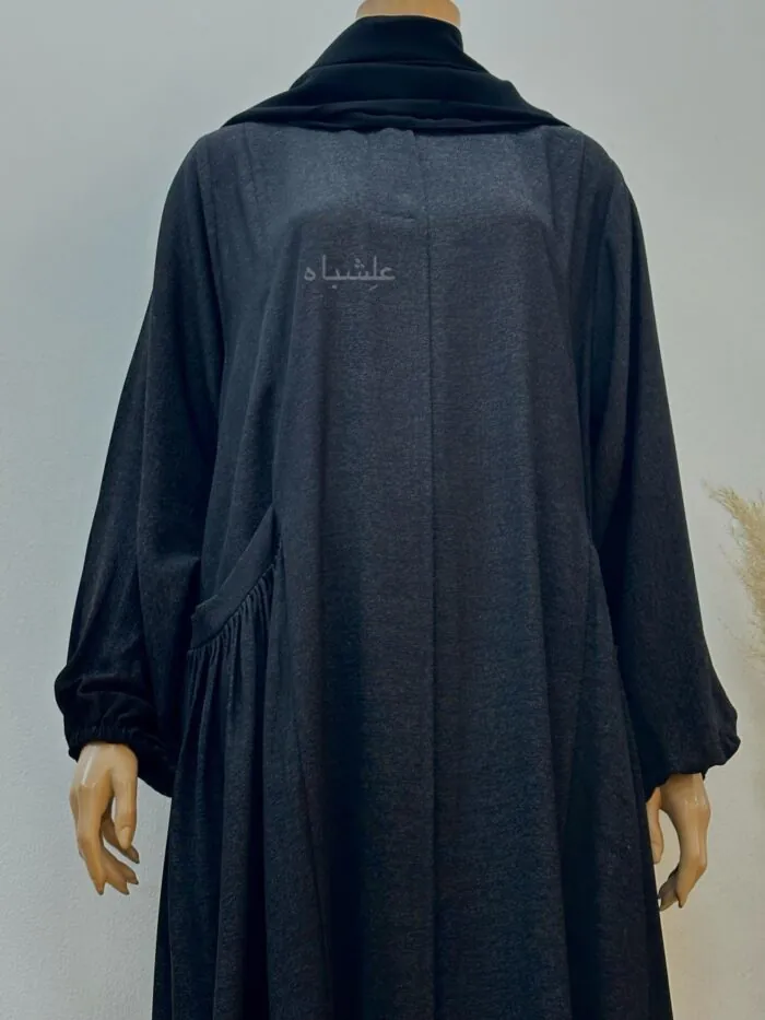 Alishbah Timeless Black Cotton Abaya. Crafted from luxurious cotton crape, this abaya features a classic design that blends tradition with modern elegance. The fabric is soft and breathable, offering comfort and subtle sheen. Thoughtfully designed side pockets add practicality without compromising style. The look is completed with a soft chiffon sheila, measuring 28” wide and 88” long, which drapes gracefully to enhance the overall ensemble. This abaya is a versatile wardrobe staple, ideal for various occasions, embodying timeless grace and sophisticated simplicity.