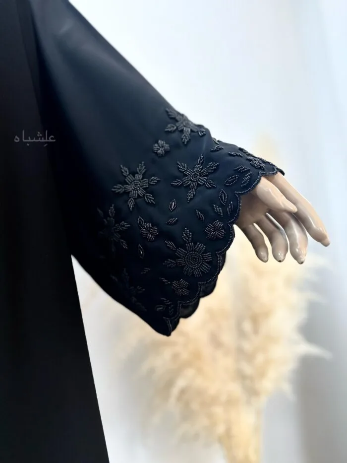 "Close-up of intricate handwork on the sleeves of the Black Midnight Abaya, featuring a delicate scallop border with detailed embroidery, showcasing fine craftsmanship."