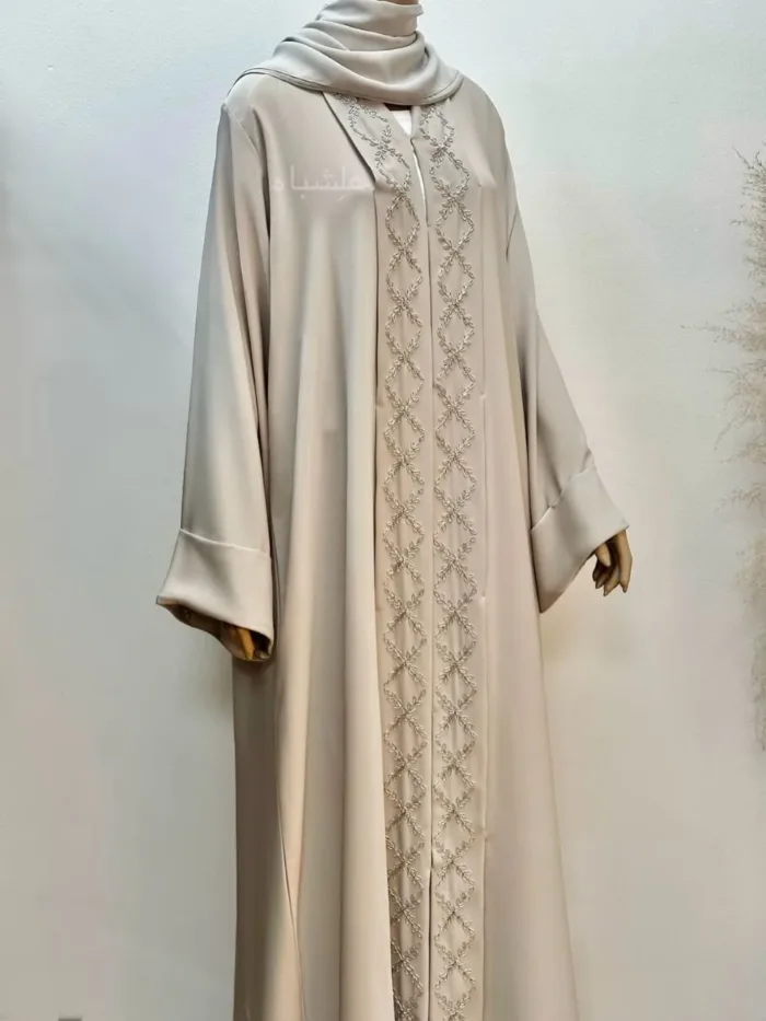 White Nida premium abaya with delicate Zardosi handwork on the front panel and neckline, paired with a soft chiffon Sheila, offering a graceful and modest appearance.