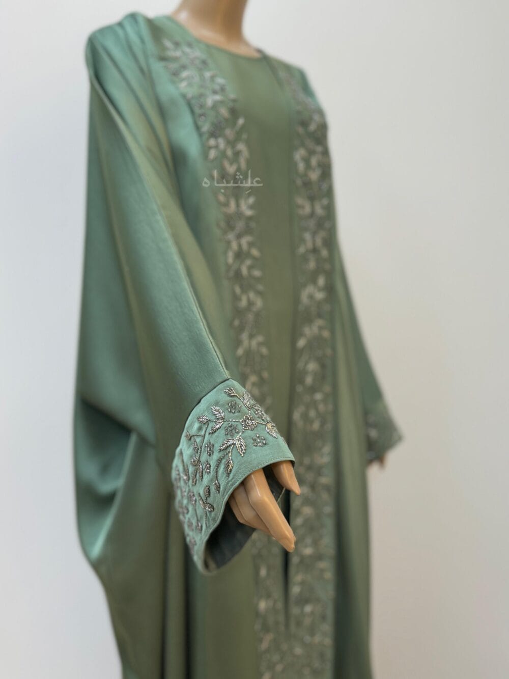 Side view of Sage green abaya with intricate floral and leaf handwork along the front and cuffs, crafted from Khaleesi fabric,