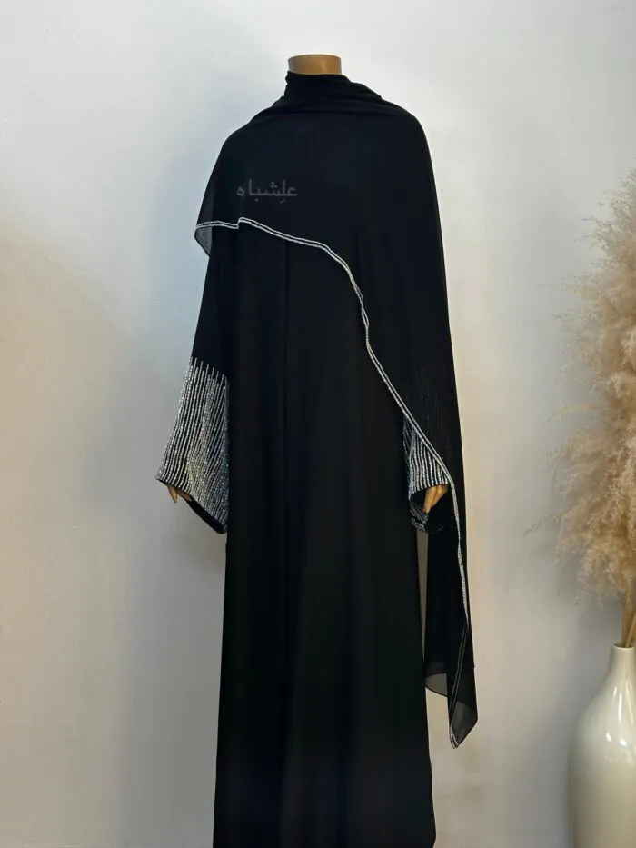 "Full view of the Crystal Noir Abaya, featuring flowing Nida fabric and delicate crystal stone detailing on the sleeves and along the side of the matching chiffon sheila, offering a blend of elegance and sophistication."