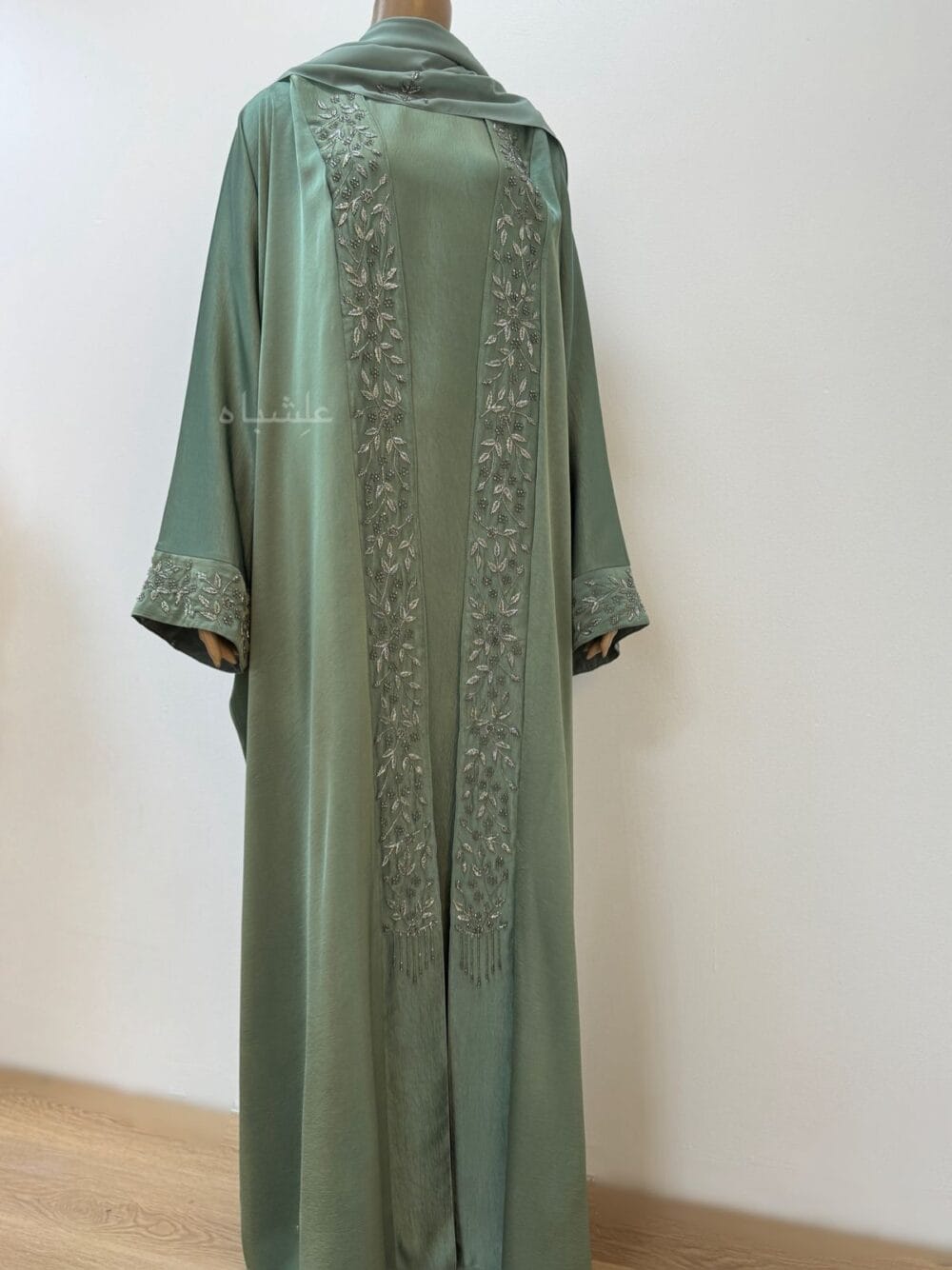 Full View of Sage green abaya with intricate floral and leaf handwork along the front and cuffs, crafted from Khaleesi fabric, paired with a matching soft chiffon Sheila.