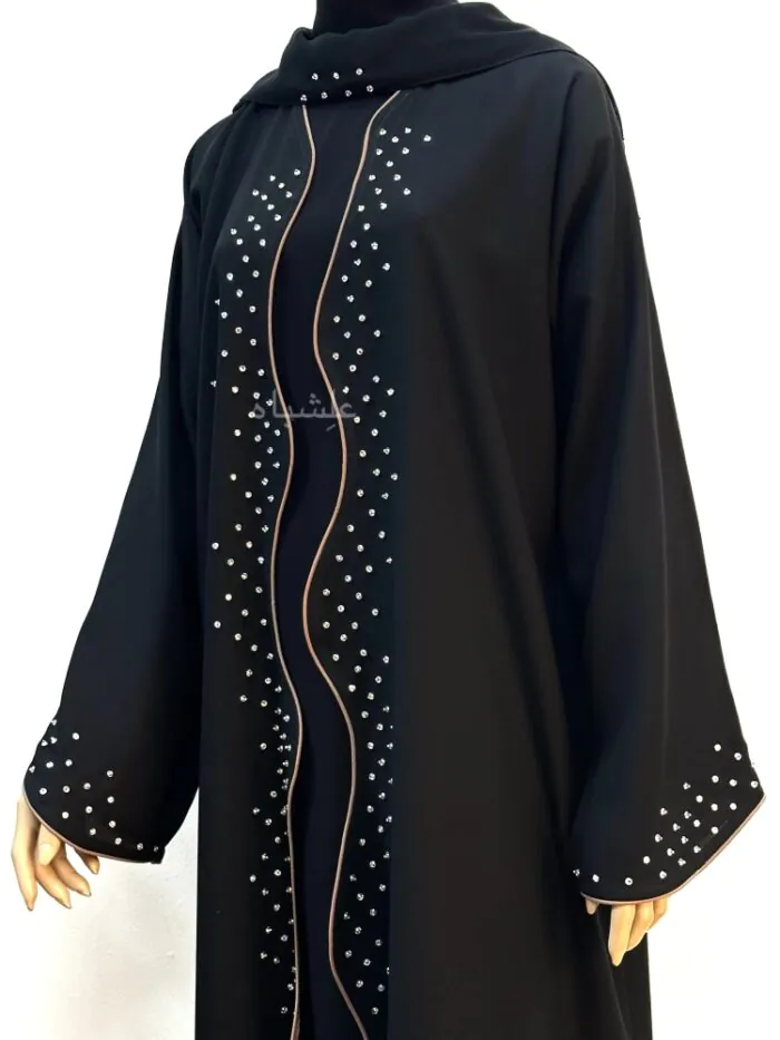 "Close-up front view of Wavy Grace Alishbah Abaya on a mannequin, highlighting hand-stitched details along the center and sleeves with matching chiffon Sheila."