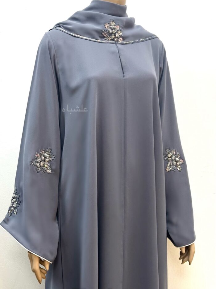 Close up view of front view of abaya with sheila showing handwork on sleeves and piping on sleeves