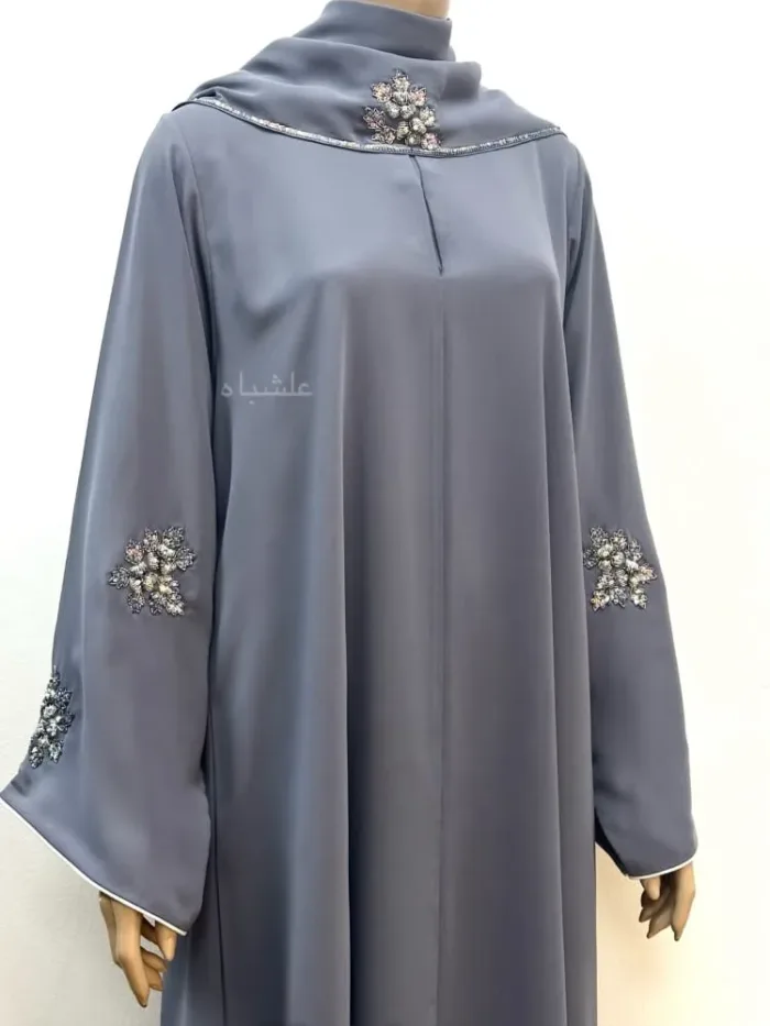 Close up view of front view of abaya with sheila showing handwork on sleeves and piping on sleeves