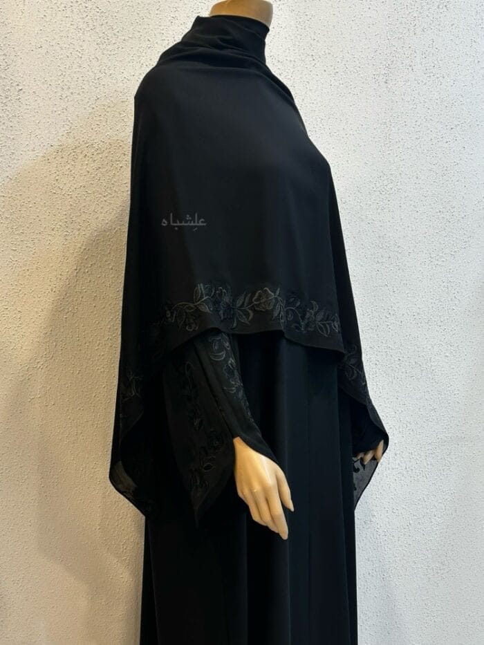 Close up side view of abaya with Sheila spread out on top showing the beautiful embroidery on long side of sheila