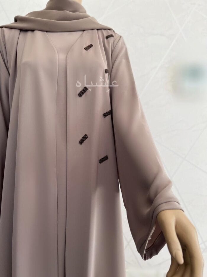 Front half view of the abaya with sleeves raised high