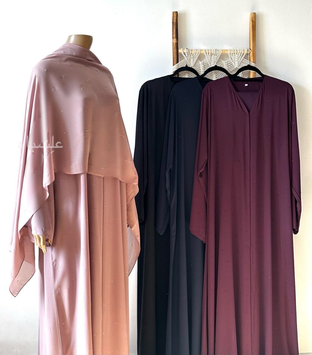 Photo of one rhine stone abaya on mannequin with 3 placed on ladder