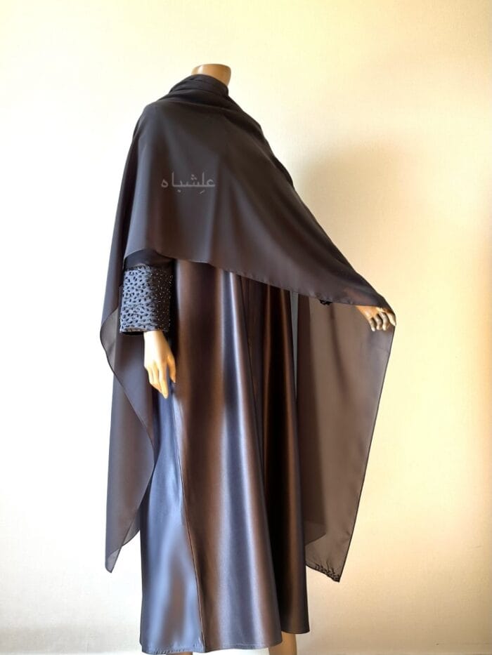 Front view of abaya with sheila spread all over with one hand raised high