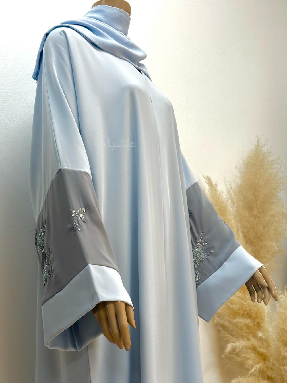 Side view of abaya with both hands raised higher