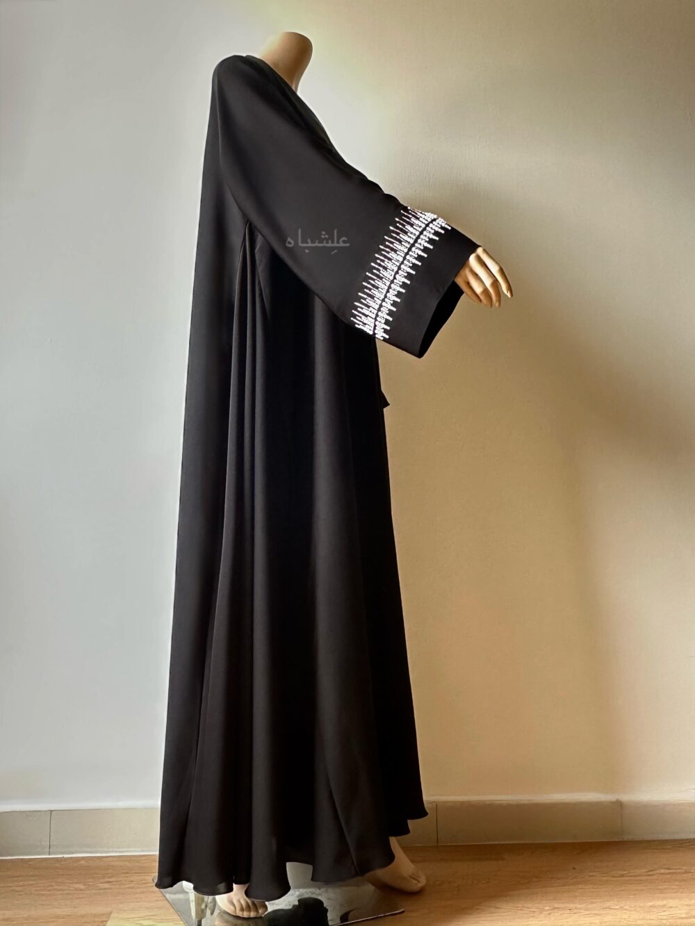 Side view of abaya with hands raised higher showing the handwork