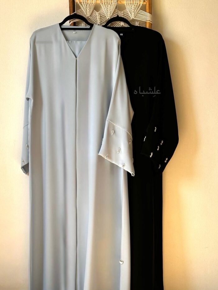 Front view of 2 abaya on a ladder black and light blue abaya