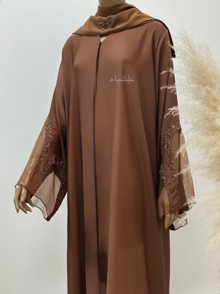 Pearl Glow Abaya 1 Close up view of abaya with one hand raised