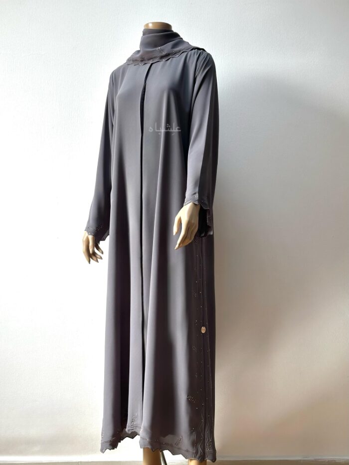 Front view of the abaya with one hand raised higher