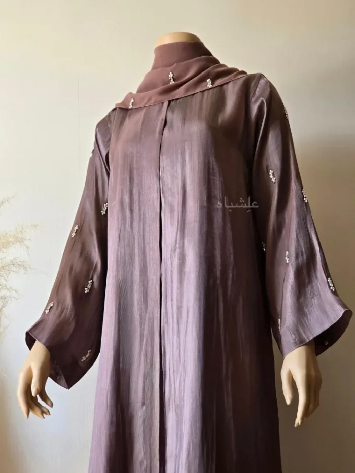 Front close up view of abaya with one hand raised higher with sheila