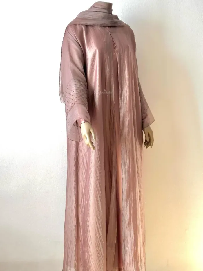 Front view of abaya with one hand raised higher with sheila