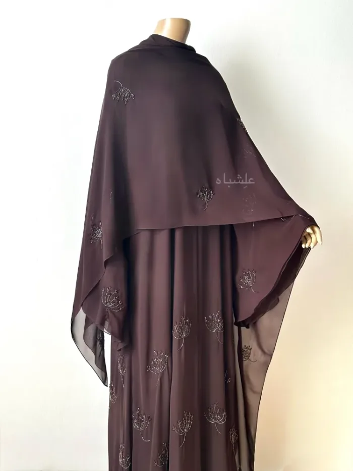 Front view of abaya with one hands raised sheila spread all over