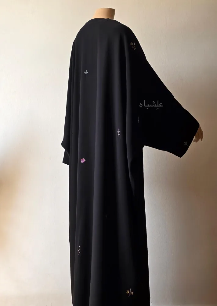 ๐ธ Petal Whisper โ Floral Handwork Abaya by Alishbah Abaya 8 Back view of the abaya with one hand raised higher