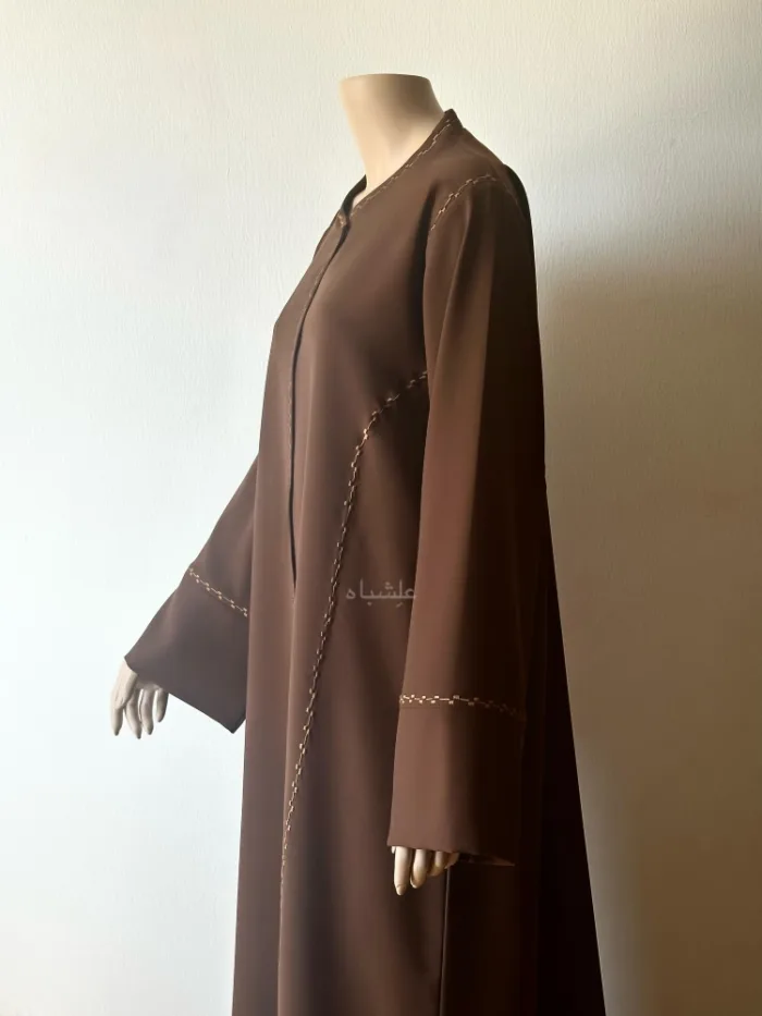 Side view of abaya with one hand raised higher