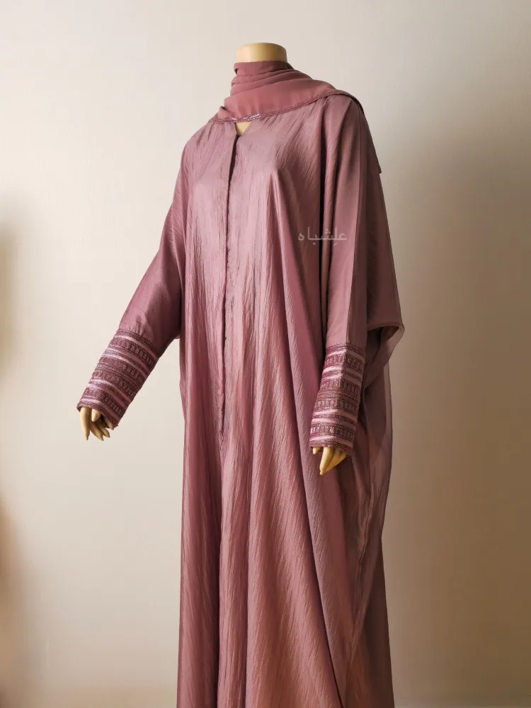 Roseline Emboss Abaya by Alishbah Abaya 1 Front view of abaya with sheila with one hand raised higher