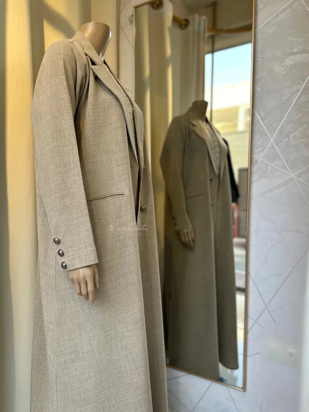 Side view of a Mannequin wearing a cream linen abaya by Alishbah, featuring elegant button details on the front and sleeves, paired with a soft chiffon Sheila."