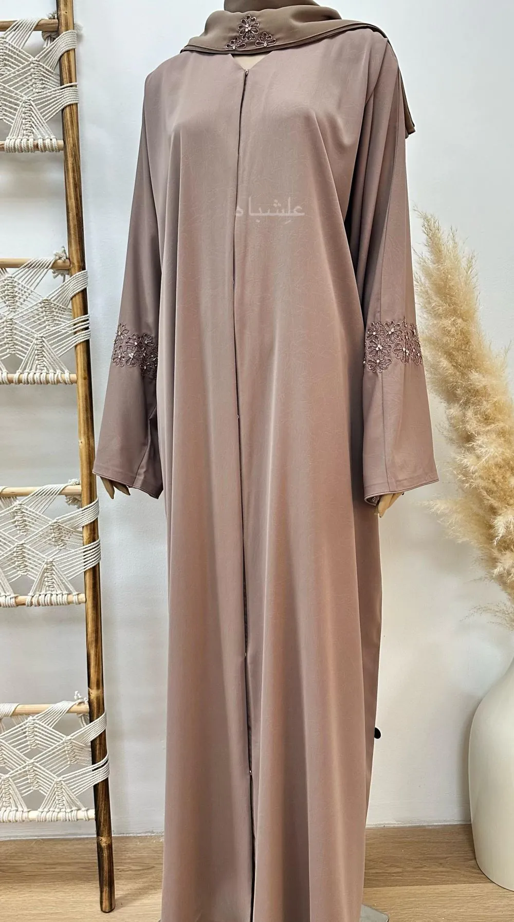 Full view of "Abaya from Alishbah crafted from Marble Crush fabric with a smooth, wrinkled texture. Features floral handwork and subtle bead accents on the sleeves and matching chiffon Sheila (28” width, 88” length)."