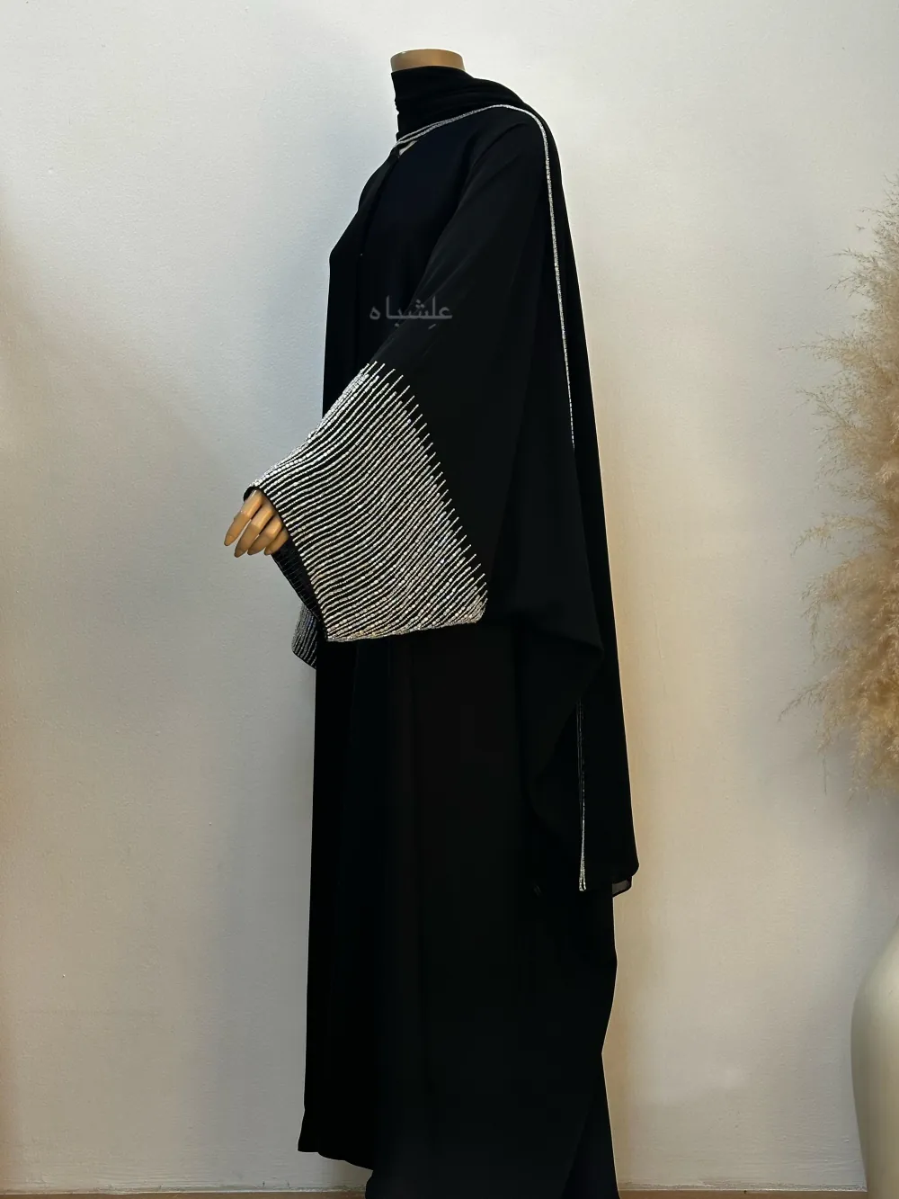 "Side view of the Crystal Noir Abaya, featuring flowing Nida fabric and delicate crystal stone detailing on the sleeves and along the side of the matching chiffon sheila, offering a blend of elegance and sophistication."