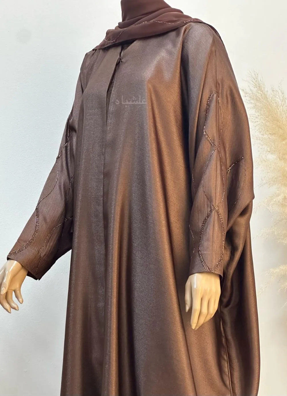 Close up side view of the Marya Satin Flow Abaya set, featuring a luxurious satin abaya with handworked sleeves, a custom pleated inner dress, and a soft chiffon sheila.