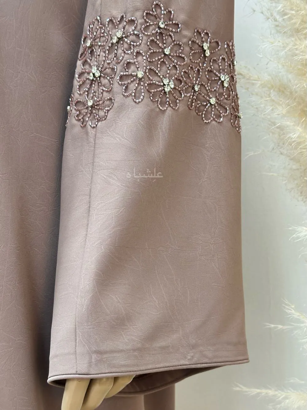 Close up view of floral handwork on sleeves