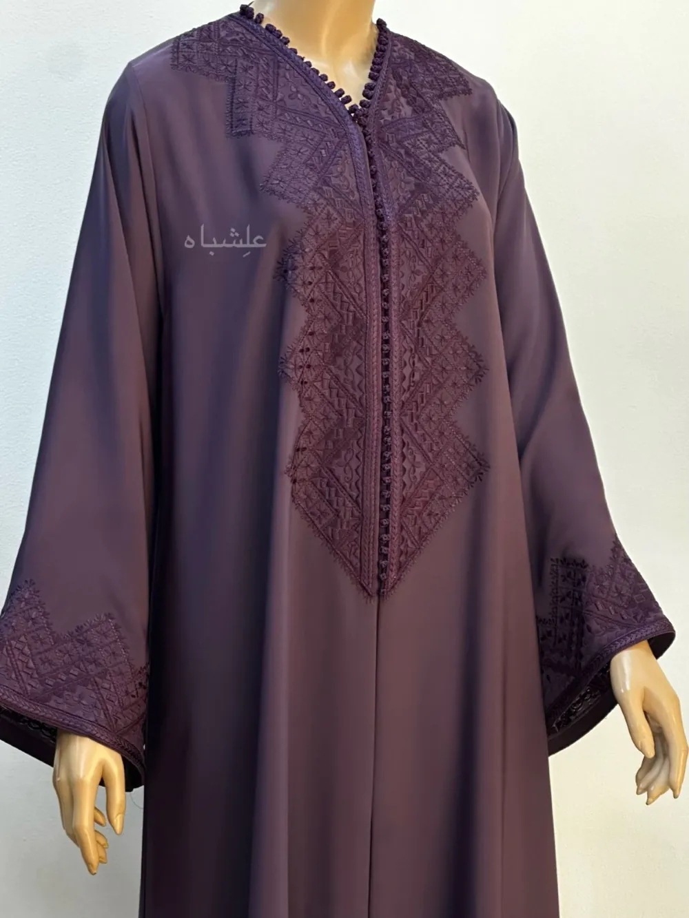 A deep purple abaya made from Nida fabric, showcasing detailed geometric Magrabi hand embroidery along the front and sleeves, without the Sheila.