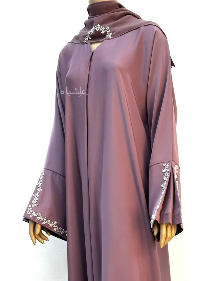 A mauve Nida Premium abaya with floral handwork on the sleeves and Sheila, featuring a folded sleeve pattern for a refined, elegant look.