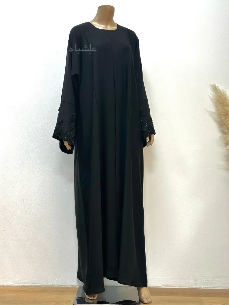 Front View of Whole Mannequin (Without Sheila)** "Front view of a mannequin wearing the Midnight Bloom abaya by Alishbah Abaya. The abaya features soft Nida fabric with subtle organza floral embroidery on the cuffs, offering a sleek and modest design perfect for formal and casual occasions."