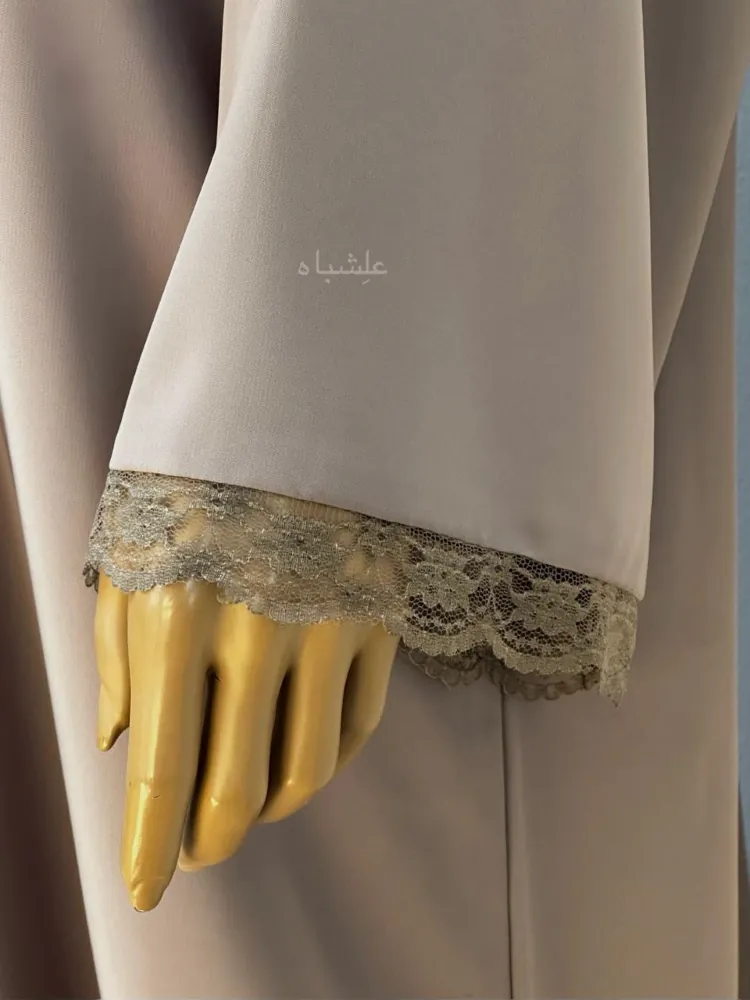 "Close-up shot of abaya sleeves, showcasing intricate lace work on the edges."