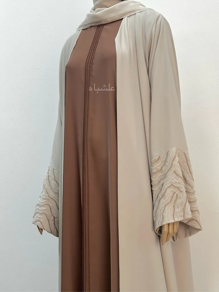 "Close-up of Radiant Harmony Abaya highlighting intricate pintuck details, matching embellishments, and premium Nida fabric texture."